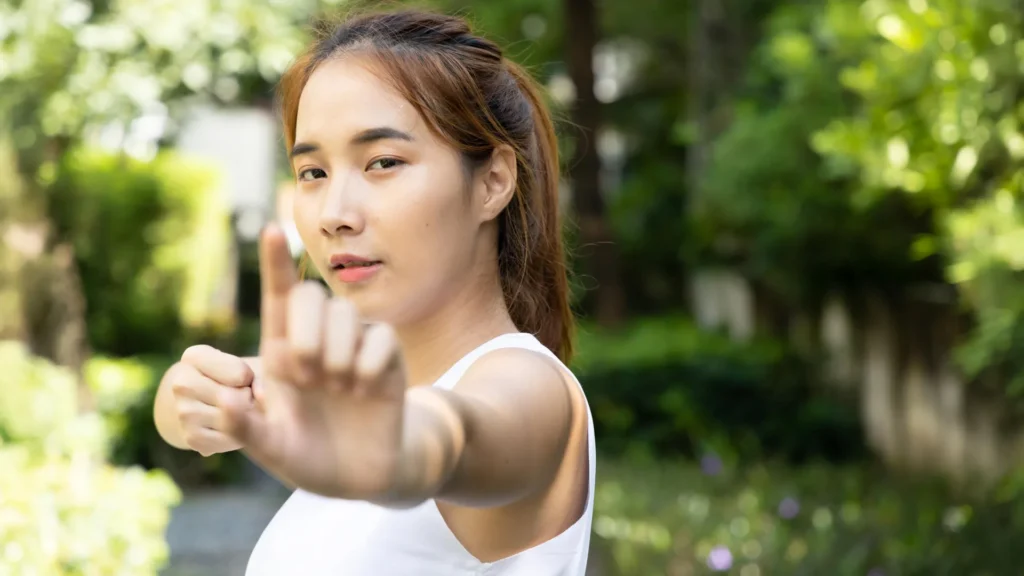 young asian woman practicing traditional chinese baduanjin kungfu qigong martial arts in park.webp.webp